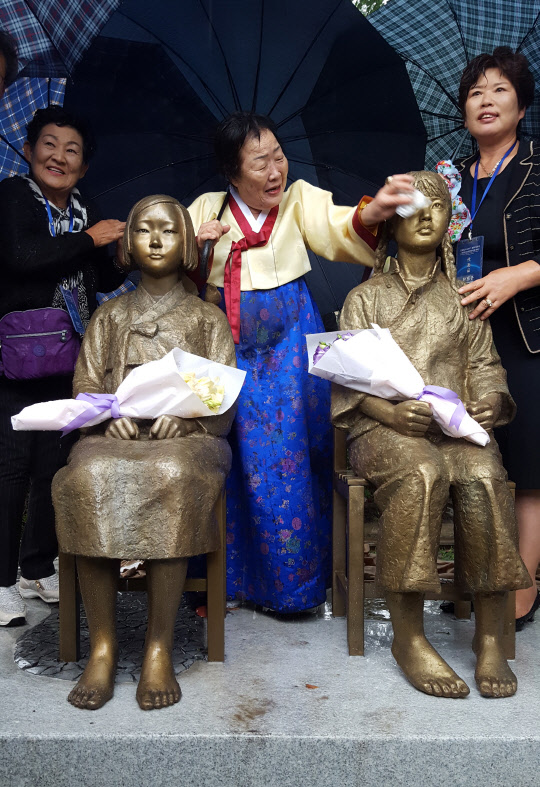 중국에도 처음으로 일본군 위안부 소녀상이 세워졌다.       '일본군 성노예 피해 문제 유네스코 세계기록유산 등재를 위한 국제연대회의'는 22일 중국 상하이사범대 원위안(文苑)루 앞 교정에 한중 위안부 '평화의 소녀상'을 제막했다.      폭우속에서 진행된 제막식에서 위안부 피해자인 한국 이용수(88) 할머니가 소녀상의 얼굴을 닦아주고 있다.